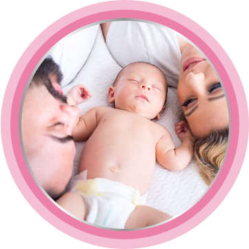 Parents laying on bed with baby in a diaper. To avoid skin irritation, it's best to use baby bottom cream.