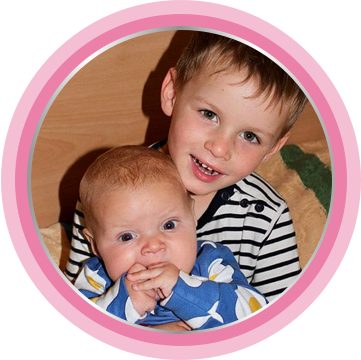 Newborn baby and young child smiling